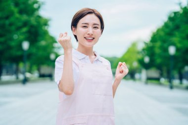 Açık havada önlüklü genç kadın.