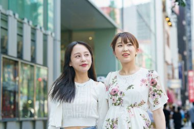 Şehirde arkadaşlarıyla alışveriş yapan genç bir kadın.