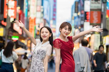 Şehir merkezinde poz veren iki genç kadın.