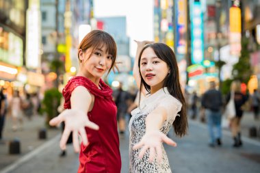 Şehir merkezinde poz veren iki genç kadın.