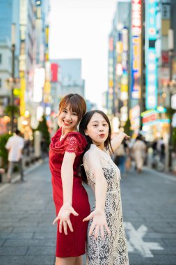 Şehir merkezinde poz veren iki genç kadın.