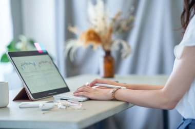 close up of a woman's hand operating a tablet PC in the room