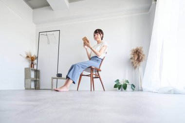 A woman reading a book in a simple bright room