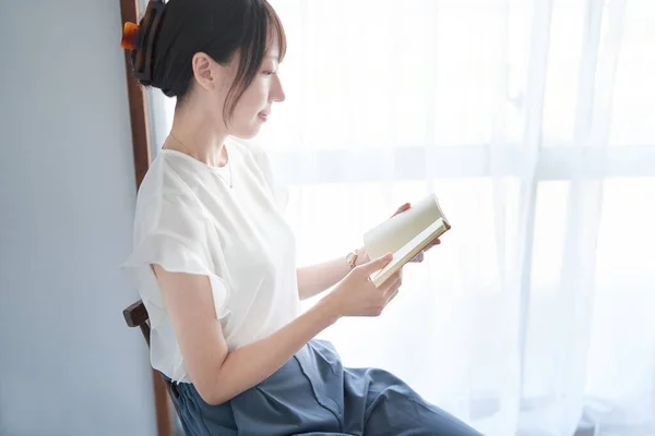 室内で本を読む若い女性 — ストック写真
