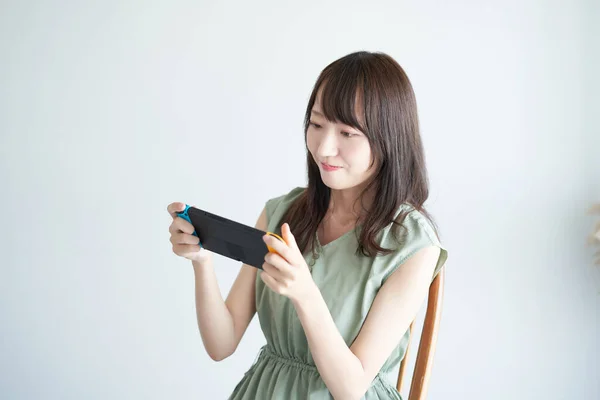 Woman Playing Portable Game Machine Room — Stockfoto