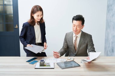 Businessman and businesswoman planning a house design