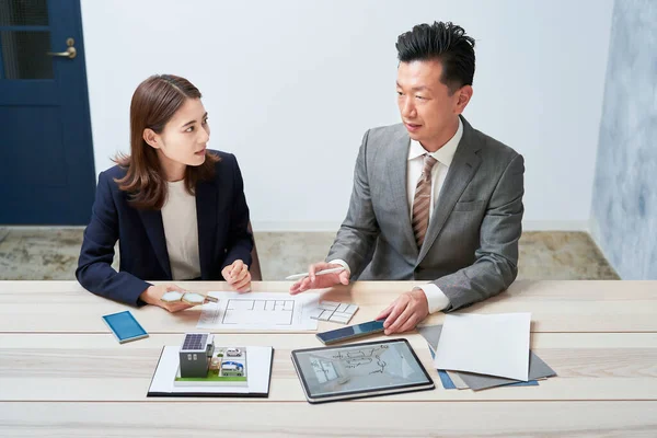 Businessman and businesswoman planning a house design