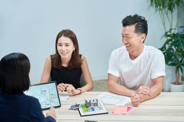 A couple receiving an explanation to purchase real estate indoors