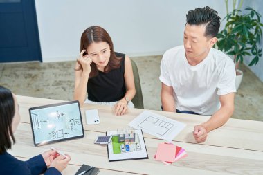 A couple receiving an explanation to purchase real estate indoors