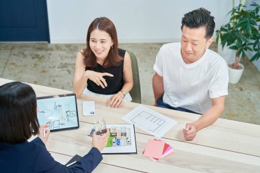 A couple receiving an explanation to purchase real estate indoors