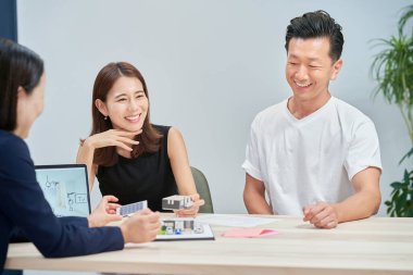 A couple receiving an explanation to purchase real estate indoors