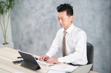 asian businessman doing desk work at office