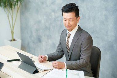 asian businessman doing desk work at office