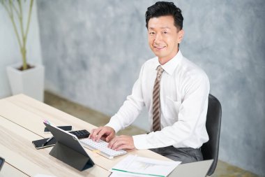 asian businessman doing desk work at office