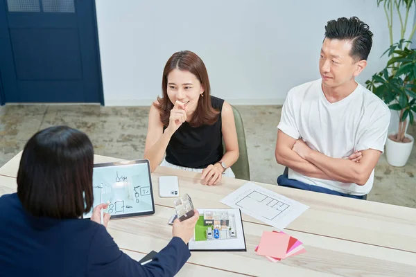 A couple receiving an explanation to purchase real estate indoors