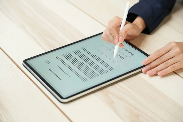 A woman signing using a tablet PC and stylus pen