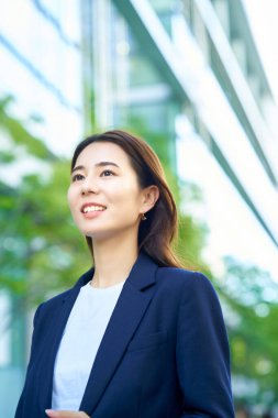 smiley business woman standing outdoors on fine day