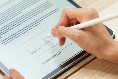 A woman signing using a tablet PC and stylus pen