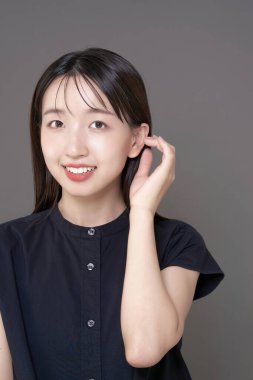 Makyajlı ve gri geçmişi olan Asyalı genç bir kadın.