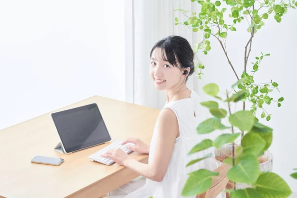 明るい部屋でタブレットPcを使う若い女性 — ストック写真