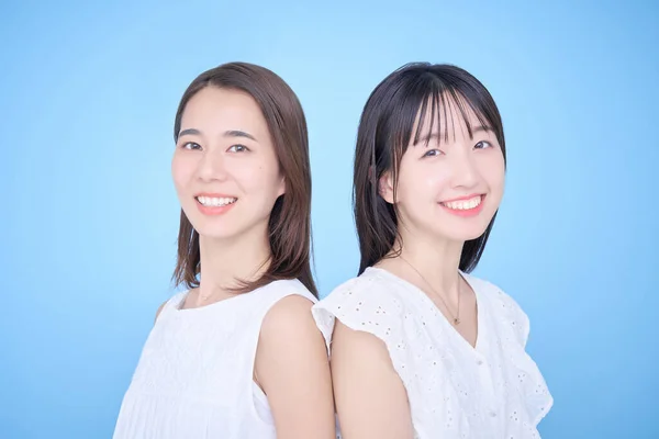 白い服を着た2人の女性が写真に収まる — ストック写真