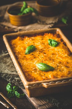 Domates soslu makarna ve peynir ve ahşap arka planda fesleğen, dikey
