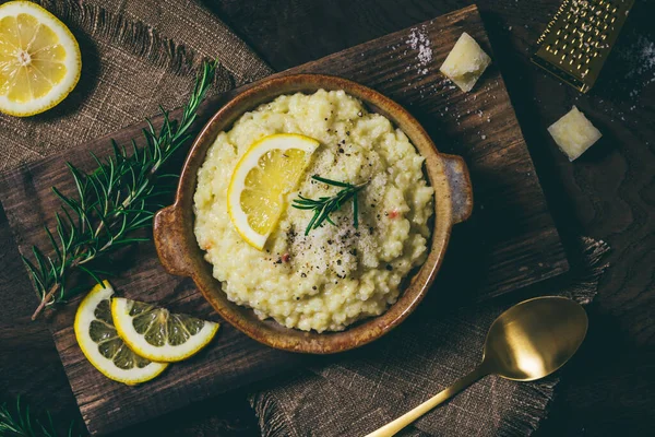 Biberiyeli limonlu pilav pilavı ve koyu ahşap arka planda taze limon dilimleri.