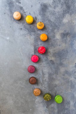 Gri beton zemin üzerinde renkli bir makaron dizisi, kopya alanı ile en üstteki görünüm