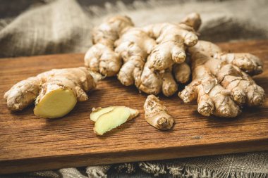 Tahtada taze zencefil, bütün kökler ve dilimler.