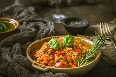 Ev yapımı risotto ya da domatesli pilav ve kırmızı dolma biber, ahşap arka plan.