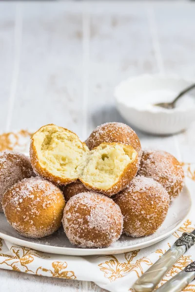 Beyaz ahşap arka planda şekerli kızarmış kaymak topları. Kahve molası kavramı. Boşluğu kopyala.