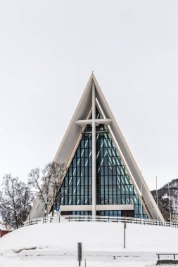 Tromso, Norveç, 3 Mart 2022 Tromsdalen Kilisesi veya Arktik Katedrali. Modern beton ve metal kilise, mimar Jan Inge Hovig tarafından hazırlanmış planlar kullanılarak 1965 yılında inşa edilmiştir. Dikey.