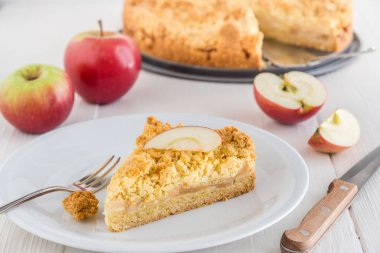 Elmalı turta, beyaz ahşap bir tabağa serpiştirilmiş.