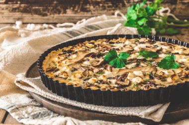 Tahta bir masada maydanozlu vejetaryen mantarlı tart.