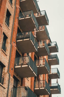 Balkonları olan eski bir tuğla binanın ön cephesi yenilendi. Dikey.