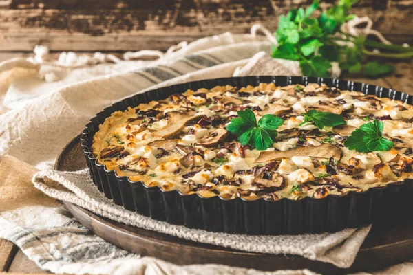 Tahta bir masada maydanozlu vejetaryen mantarlı tart.