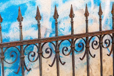 Arkasında grafiti olan demir bahçe çiti.