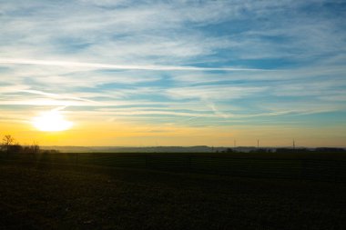 Thüringen 'de gün doğumunda rüzgar türbinleri, güneş enerjisi