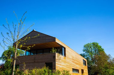 Mavi gökyüzü ve yan manzaralı modern ahşap ev