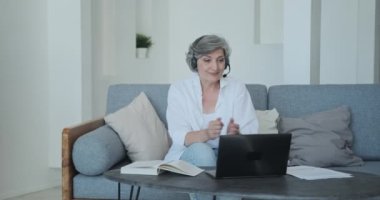 Kıdemli bayan öğretmen öğrencileri selamlıyor ve eğitici video konferansına başlıyor..