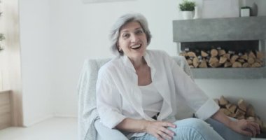 Gülümseyen 60 'lı yaşlarda orta yaşlı bir bayan video konferans çağrısı yapıyor.