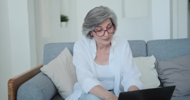 A avó sorrindo positivo se comunica com seus filhos e netos remotamente nas mídias sociais — Vídeo de Stock