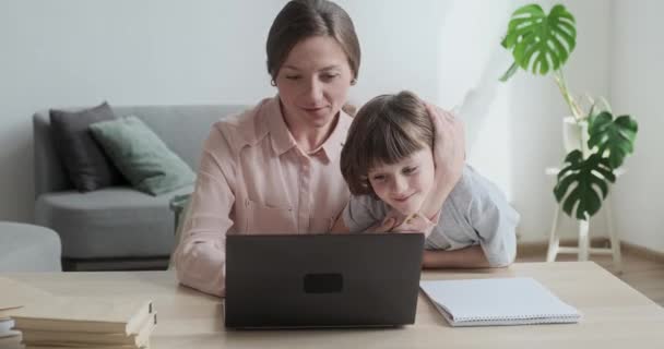 Mamá e hijo usando el portátil juntos, navegando por Internet, comprando y jugando. — Vídeos de Stock
