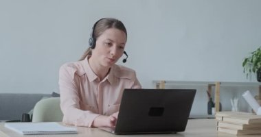 Çevrimiçi video görüşmesi sırasında web kamerasıyla konuşan mutlu genç bir kadın..