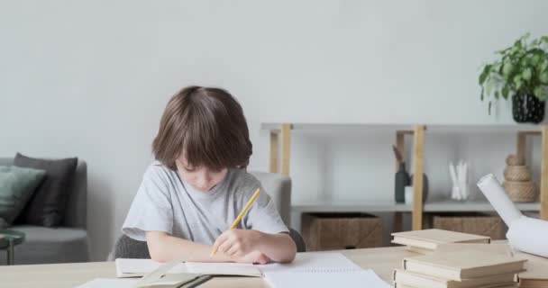 Солідарний, уважний, старанний 6-річний школяр вчить писати і малювати з дому — стокове відео