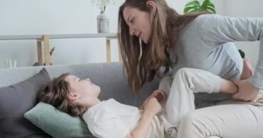Neşeli, sevgi dolu genç bir anne oğluna sarılıyor ve onu öpüyor..