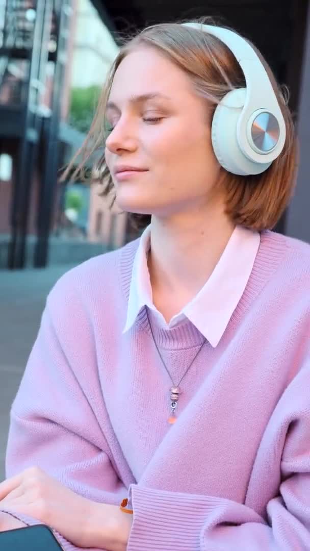 Melancólica estudiante de auriculares escucha música — Vídeos de Stock