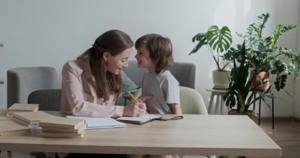 Уважний, смішний малюк старанно вчиться писати і малювати зі своєю дбайливою матір'ю вдома . — стокове відео