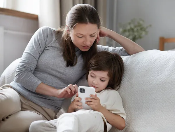 Sebevědomá matka učení malý syn použití smartphone surfing internet užitečné aplikace a volání — Stock fotografie
