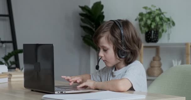 Anak manis belajar online jarak jauh dengan panggilan video menggunakan laptop. Seorang murid sekolah anak belajar — Stok Video